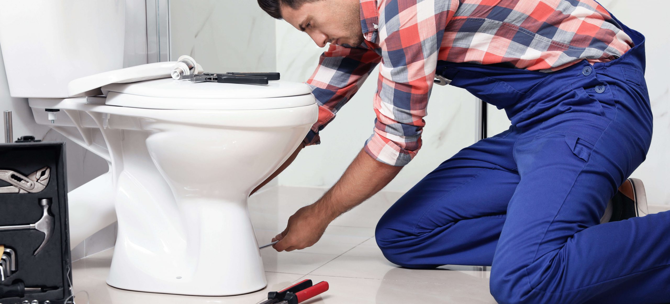 A plumber removing a toilet