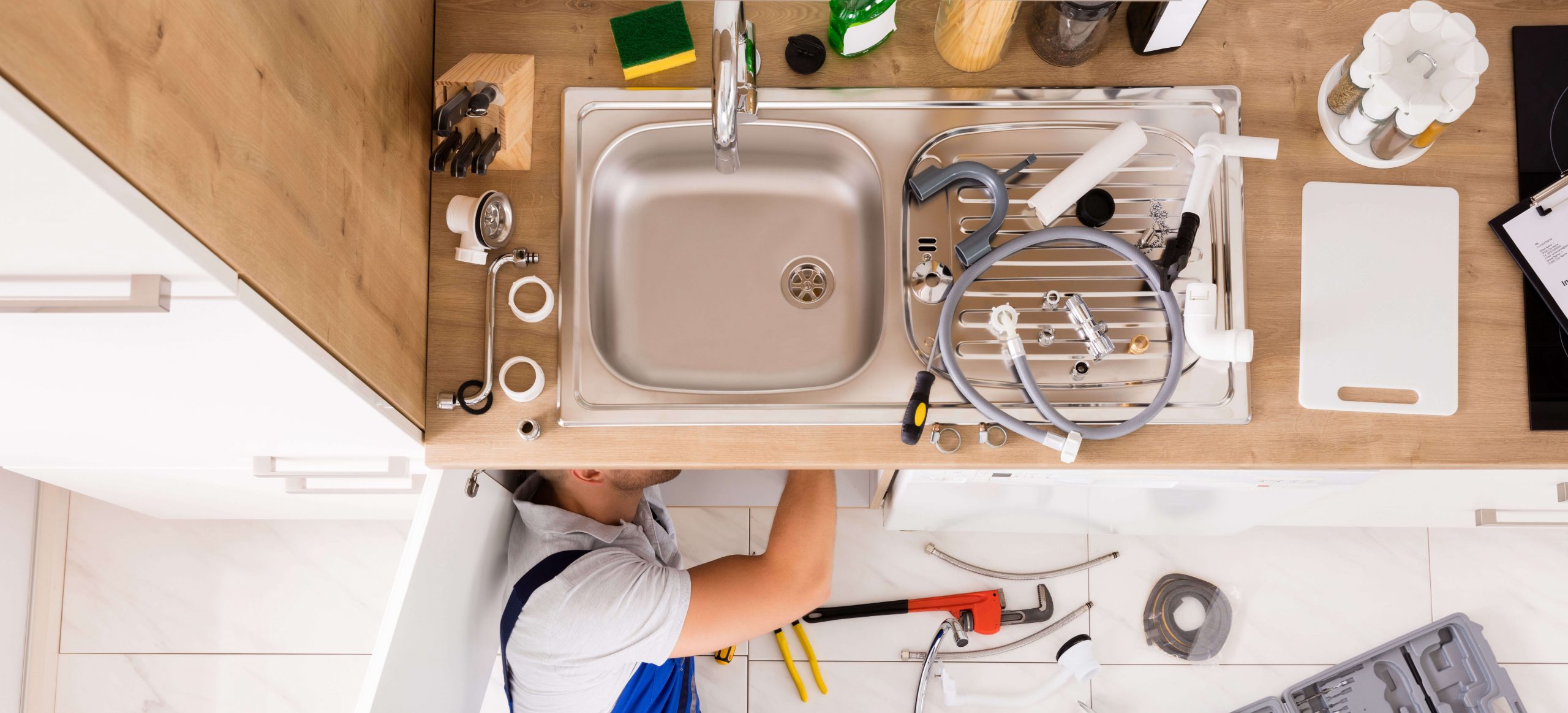 A plumber replacing a kitchen sink